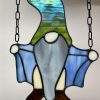 Naughty flashing gnome stained glass. green hat, gray beard, blue coat.